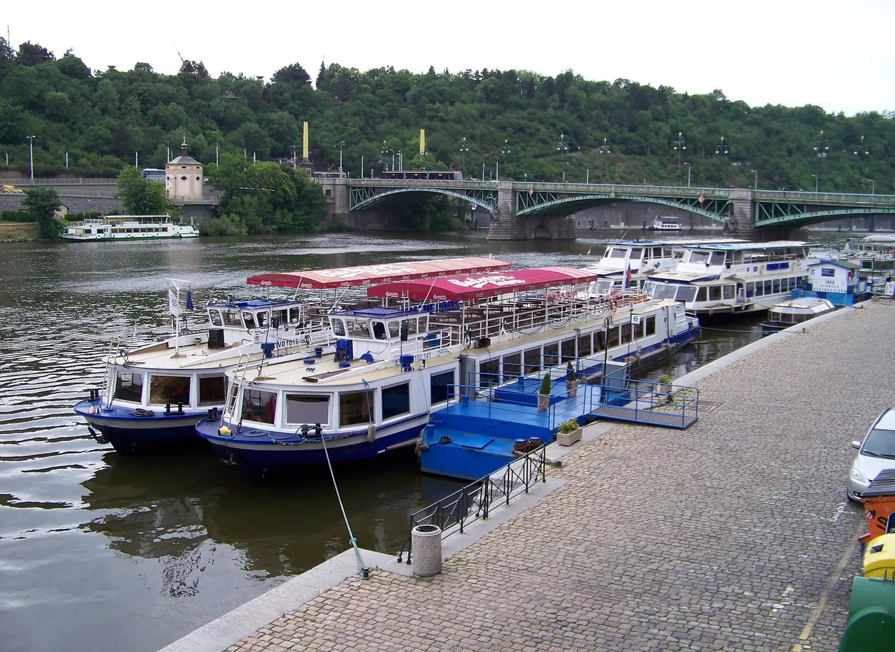 เรือล่องเที่ยวหลายลำจอดที่ Dvořákovo nábřeží ใกล้สะพาน Čech ภาพจาก Wikimedia Commons ผู้ถ่าย ŠJů สัญญา CC BY-SA 3.0 ปีที่ถ่ายไม่ระบุ เรือและป้ายผู้ให้บริการอาจเปลี่ยนไปแล้ว