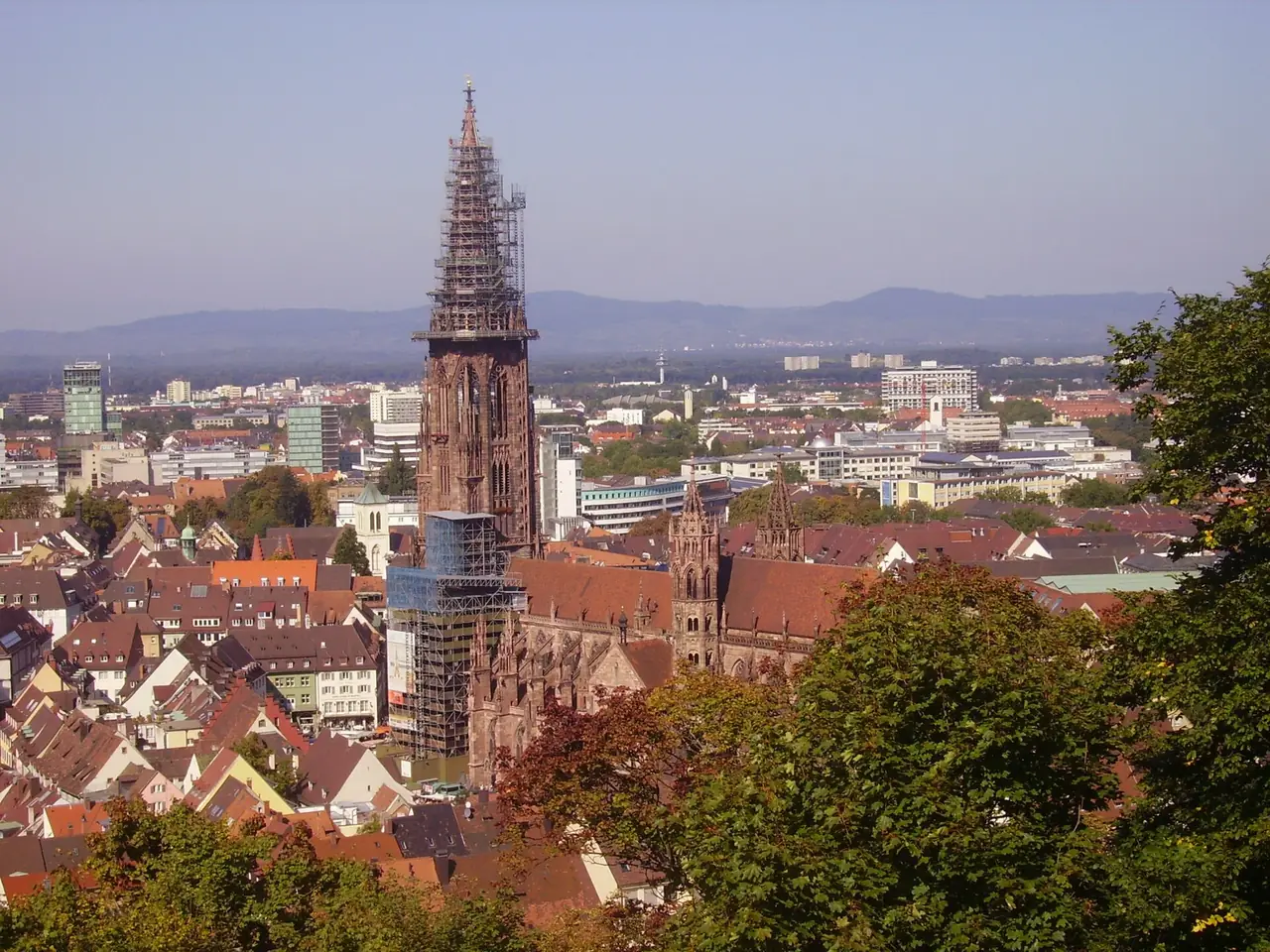 มุมมองไฟรบวร์กจากเนินเขา Schlossberg เห็นยอดโบสถ์ Münster กำลังมีนั่งร้านล้อม ภาพจาก Wikimedia Commons ผู้ถ่าย Zairon สัญญา CC BY-SA 3.0 ปีที่ถ่ายไม่ระบุ นั่งร้านที่เห็นอาจไม่มีแล้วในวันที่คุณไป