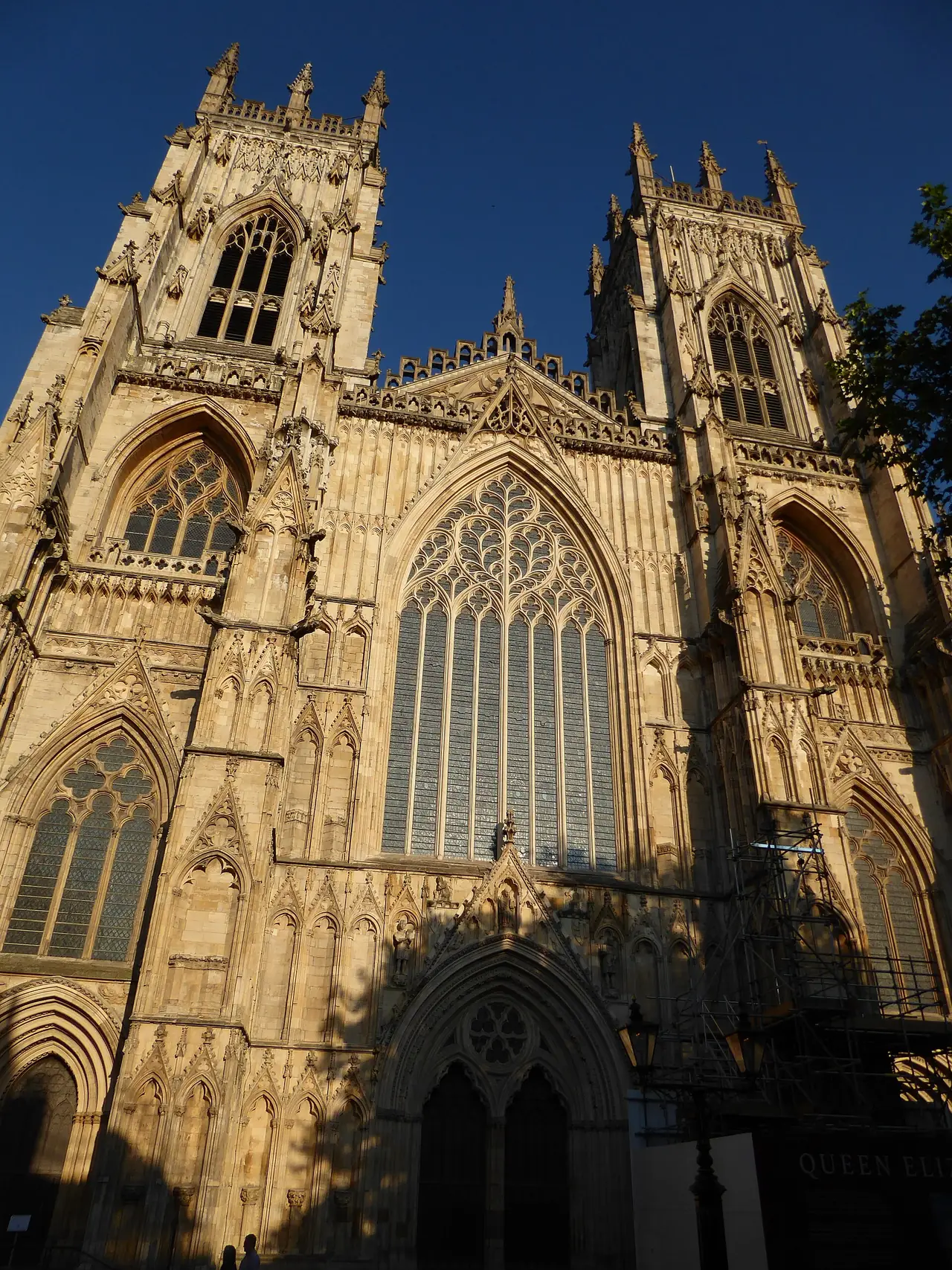 ด้านหน้าฝั่งตะวันตกของ York Minster ยามแดดเย็น ภาพจาก Wikimedia Commons ผู้ถ่าย Chris Holifield สัญญา CC BY-SA 2.0 ไม่ระบุปีที่ถ่าย มีนั่งร้านที่มุมขวาของภาพ