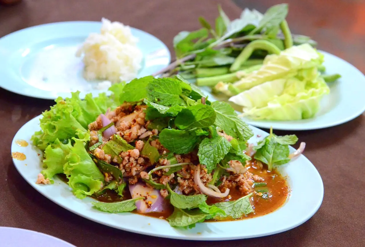ลาบหมูอีสานกับผักสดและข้าวเหนียว ตามคำอธิบายบนคอมมอนส์ถ่ายที่ร้านอาหารอีสานในกรุงเทพฯ ภาพจาก Wikimedia Commons ผู้ถ่าย Takeaway สัญญา CC BY-SA 3.0 ไม่ได้ถ่ายในอีสาน
