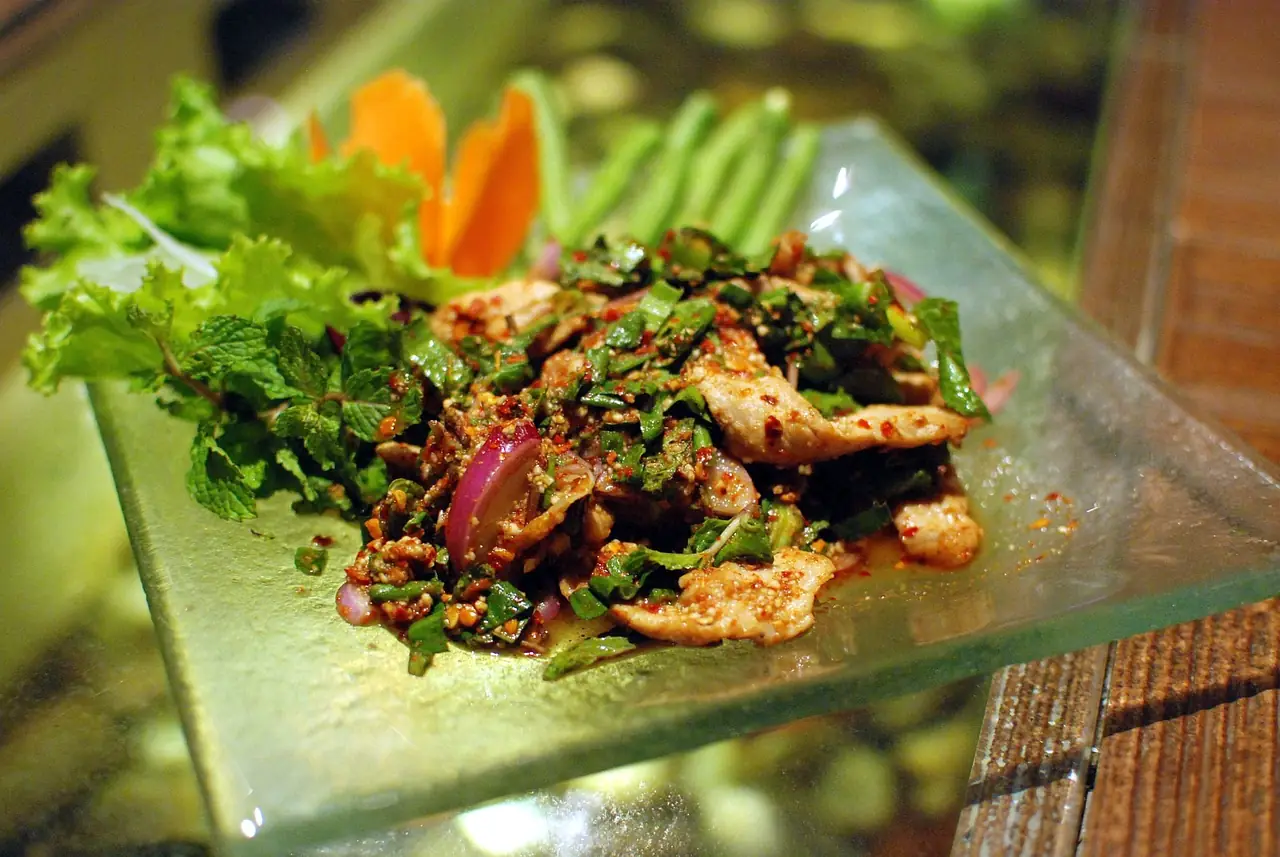 หมูน้ำตก สลัดหมูย่างหั่นชิ้นกับสะระแหน่ในจานแก้ว ตามชื่อไฟล์บนคอมมอนส์ ภาพจาก Wikimedia Commons ผู้ถ่าย Takeaway สัญญา CC BY-SA 3.0 เป็นภาพประกอบ ไม่ใช่ร้านในอีสาน