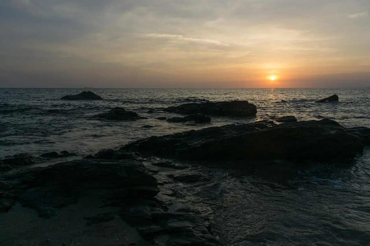 พระอาทิตย์ตกเหนือโขดหินที่ชายฝั่งหาดนุ้ย เกาะลันตาใหญ่ ถ่ายเมษายน 2561 ภาพถ่ายจาก Wikimedia Commons ผู้ถ่าย Alexey Komarov สัญญา CC BY-SA 4.0