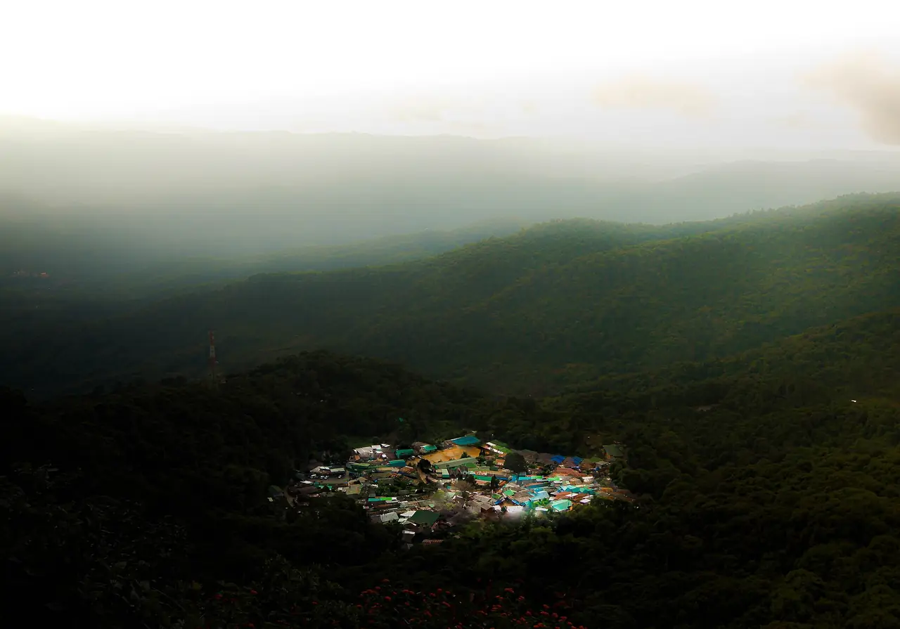 หมู่บ้านบนสันเขามองจากมุมสูงท่ามกลางป่าและหมอก ภาพจาก Wikimedia Commons ผู้ถ่าย Tle.sorakrai สัญญา CC BY 4.0 ชื่อไฟล์ระบุว่าเป็นหมู่บ้านชนเผ่าม้งกลางภูเขาดอยสุเทพ-ปุย ไม่ลงวันที่ถ่ายและไม่ระบุชื่อหมู่บ้าน เป็นภาพประกอบ