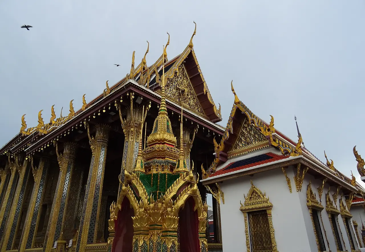 มุมหนึ่งของพระอุโบสถวัดพระศรีรัตนศาสดาราม เสาประดับกระจกและช่อฟ้าใบระกาปิดทอง ภาพจาก Wikimedia Commons ผู้ถ่าย Christophe95 สัญญา CC BY-SA 4.0