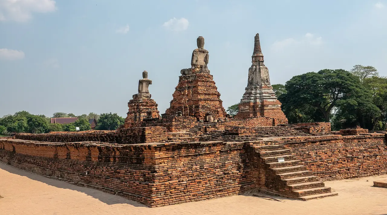 ฐานอิฐและพระพุทธรูปไร้เศียรบนฐานชั้นต่าง ๆ ของวัดไชยวัฒนาราม มีเจดีย์เล็กอยู่ด้านขวา ภาพจาก Wikimedia Commons ผู้ถ่าย No(0)GoodNamesLeft สัญญา CC BY-SA 4.0 ไม่ทราบวันที่ถ่าย