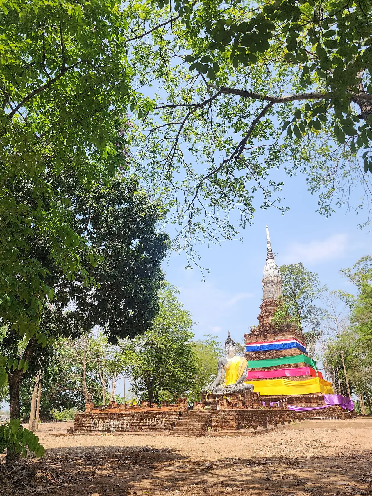 เจดีย์อิฐมีพระพุทธรูปนั่งอยู่หน้าฐาน และมีผ้าหลายสีพันรอบฐานเจดีย์ ตามชื่อไฟล์คือ Wat Thao Saen Pom อยู่ในหมวดโบราณสถานของจังหวัดกำแพงเพชรบนคอมมอนส์ ถ่ายวันที่ 15 เมษายน 2568 ในโครงการ Wiki Loves Monuments เราไม่ยืนยันว่าอยู่ห่างเมืองไตรตรึงษ์เท่าใด ใช้เป็นภาพประกอบโบราณสถานอิฐของจังหวัดและเป็นชื่อที่ตรงกับตำนานท้าวแสนปมในหน้านี้ ไม่ใช่ภาพเมืองไตรตรึงษ์ ภาพจาก Wikimedia Commons ผู้ถ่าย Tang2bar สัญญา CC BY-SA 4.0