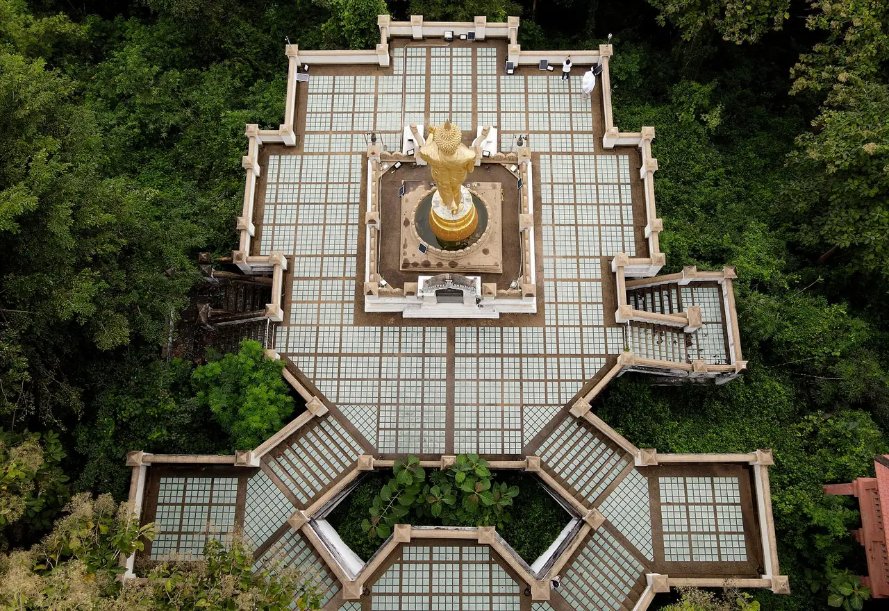 ภาพถ่ายตรงลงจากด้านบนของลานพระพุทธรูป เห็นลานกระเบื้องที่มีรูปทรงหลายแฉก มีทางลดระดับและบันไดอยู่รอบลาน และป่าไม้สีเขียวล้อมรอบ ภาพจาก Wikimedia Commons ผู้ถ่าย Yakuzakorat สัญญา CC BY-SA 4.0 ไม่ลงวันที่ถ่าย ภาพนี้ใช้ดูผังลานเท่านั้น นับจำนวนขั้นบันไดไม่ได้
