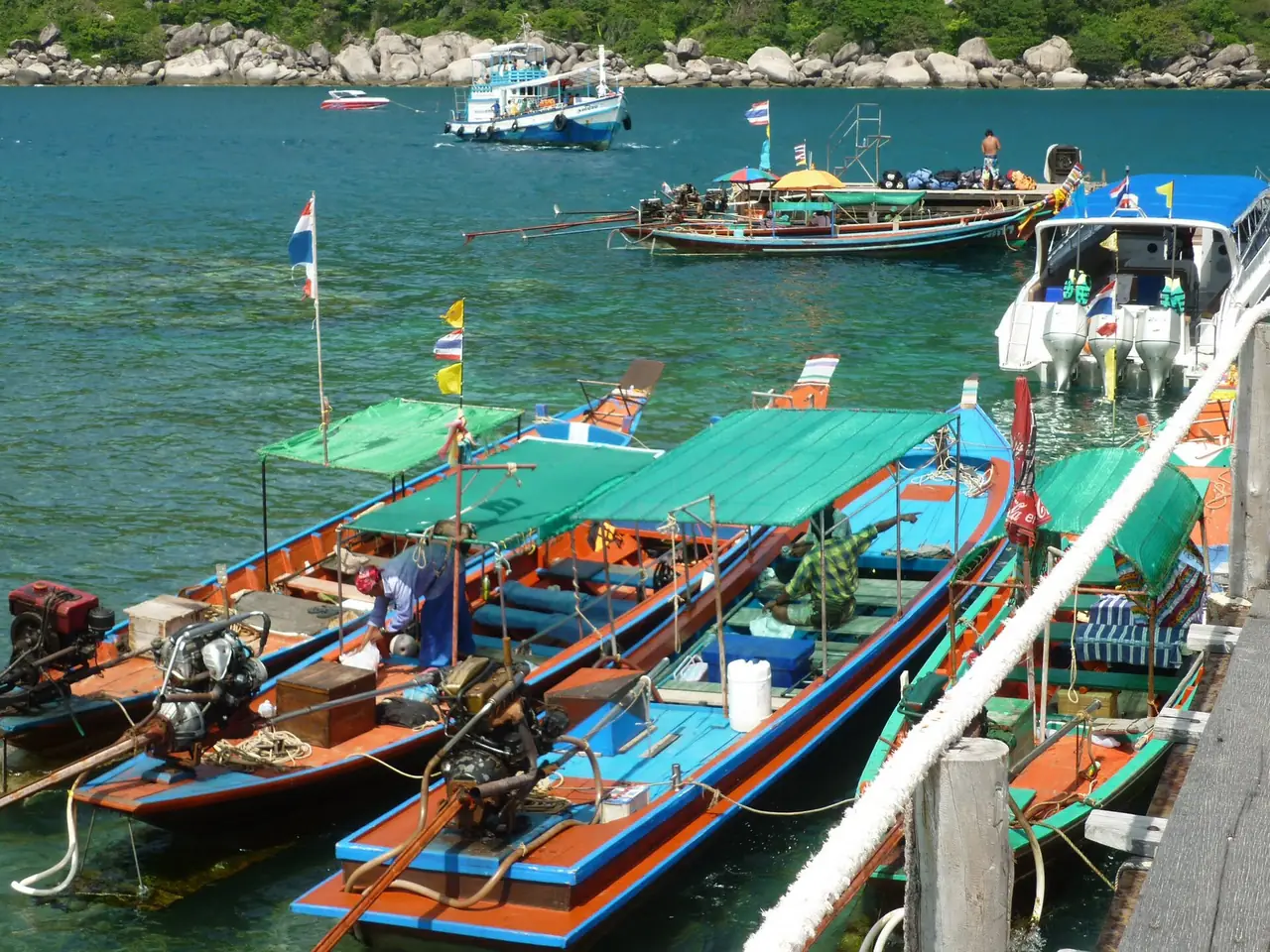 เรือหางยาวหลายลำจอดข้างท่าไม้ มีเรือโดยสารใหญ่ลอยอยู่ไกลออกไป ภาพที่ Commons ระบุว่าเรือหางยาวที่เกาะนางยวน ของ Dirk Enthoven จาก Wikimedia Commons สัญญา CC BY 3.0 เป็นภาพประกอบ ไม่ใช่เรือและราคาปัจจุบัน