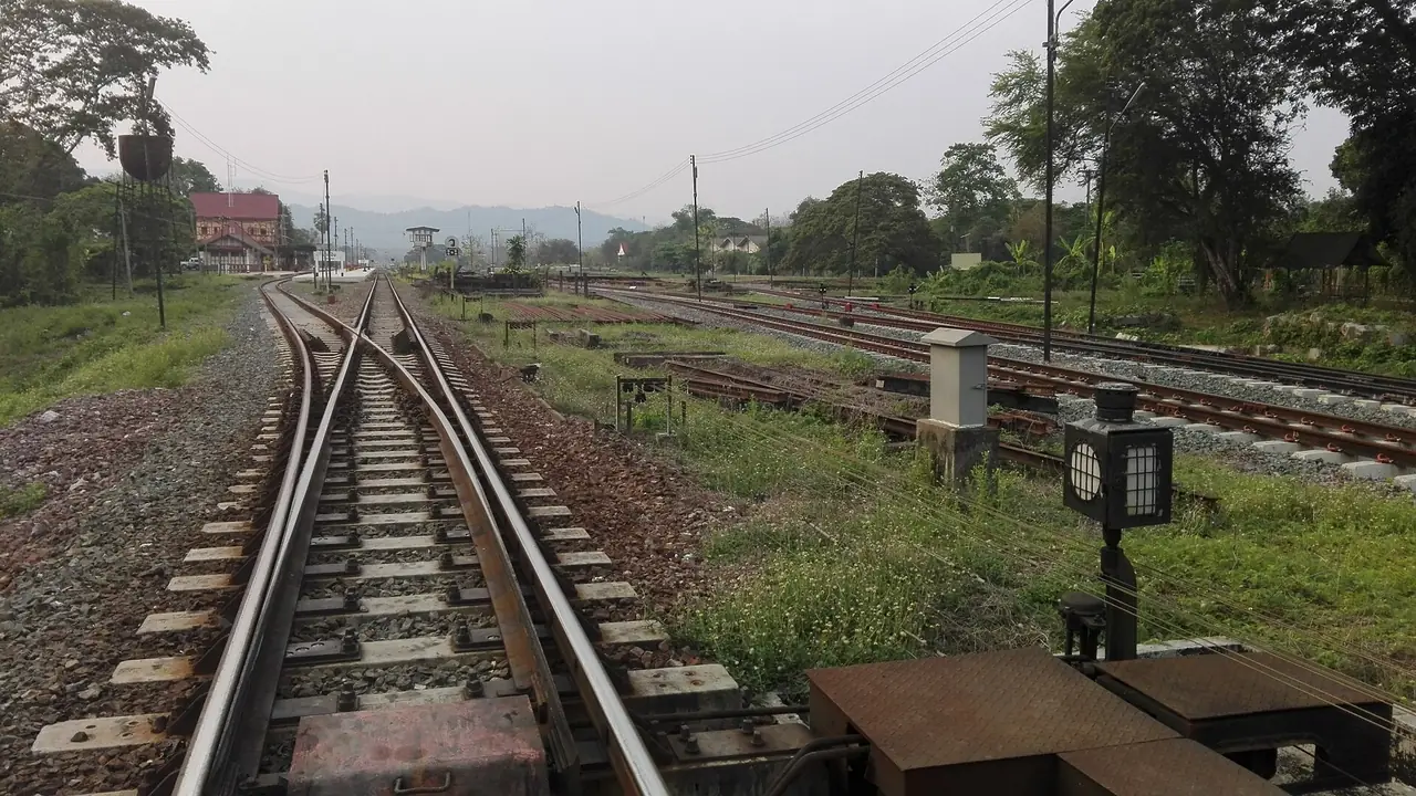 รางรถไฟ สัญญาณ และย่านสถานีบ้านปินมองจากหัวขบวน อาคารสถานีอยู่ไกลทางซ้ายมือ ภาพจาก Wikimedia Commons ผู้ถ่าย Paweeraphat Thasee สัญญา CC BY-SA 4.0 ชื่อไฟล์ระบุเพียงรหัสสถานี