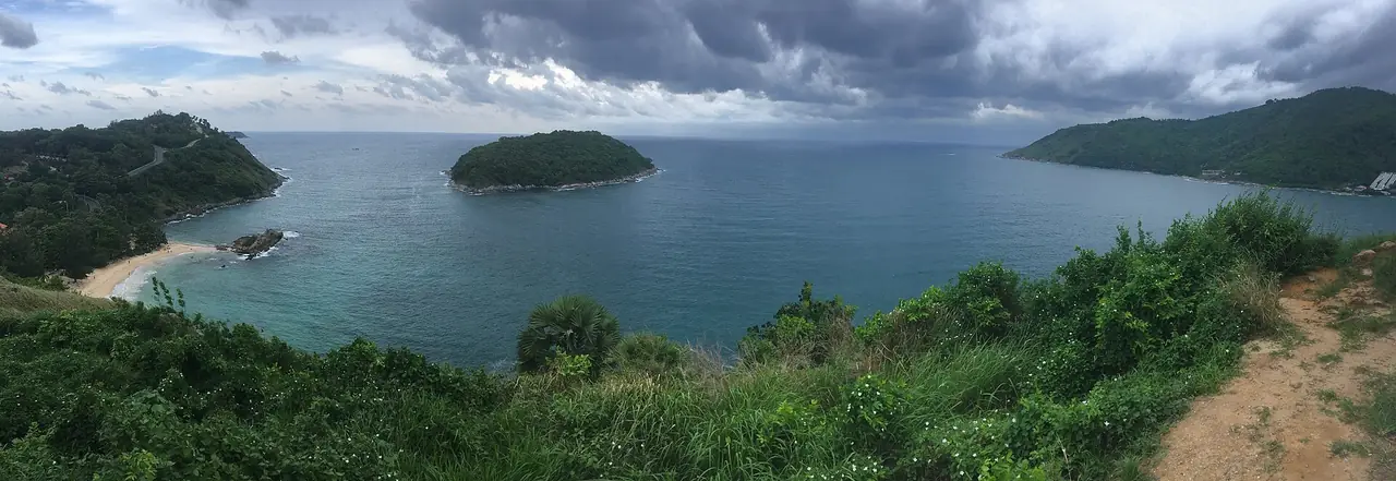 ภาพพาโนรามามองจากเนินเขา เห็นอ่าวเล็กและหาดทรายขาวทางซ้าย เกาะเขียวเล็กกลางน้ำและแหลมเขียวทางขวา ชื่อไฟล์ระบุว่ามองจากจุดชมวิวกังหันลมในภูเก็ตตะวันตกเฉียงใต้เห็นเกาะมันและหาดยะนุ้ย ภาพจาก Wikimedia Commons ผู้ถ่าย Christophe95 สัญญา CC BY-SA 4.0 ไม่ระบุปีที่ถ่าย ภาพถูกครอบให้กว้างและย่อมาก เป็นภาพประกอบ