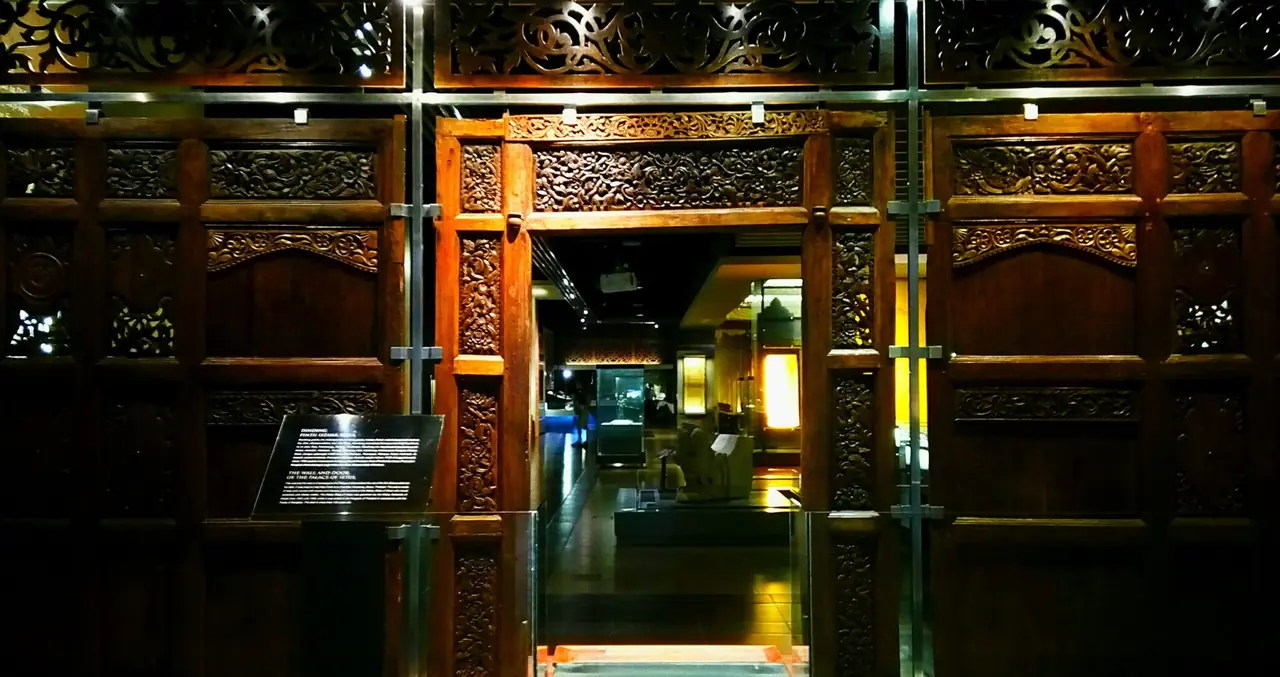 แผงประตูไม้แกะสลักจากพระตำหนักเมืองสตูลโบราณ (Setul Mambang Segara) ที่จัดแสดงในพิพิธภัณฑ์ ภาพจาก Wikimedia Commons ผู้ถ่าย The Bangsawan สัญญา CC BY-SA 4.0 Commons ไม่ระบุว่าอยู่พิพิธภัณฑ์ใด ไม่ใช่คฤหาสน์กูเด็นและไม่ใช่ถ้ำ ใช้เป็นภาพประกอบประวัติเมืองเท่านั้น